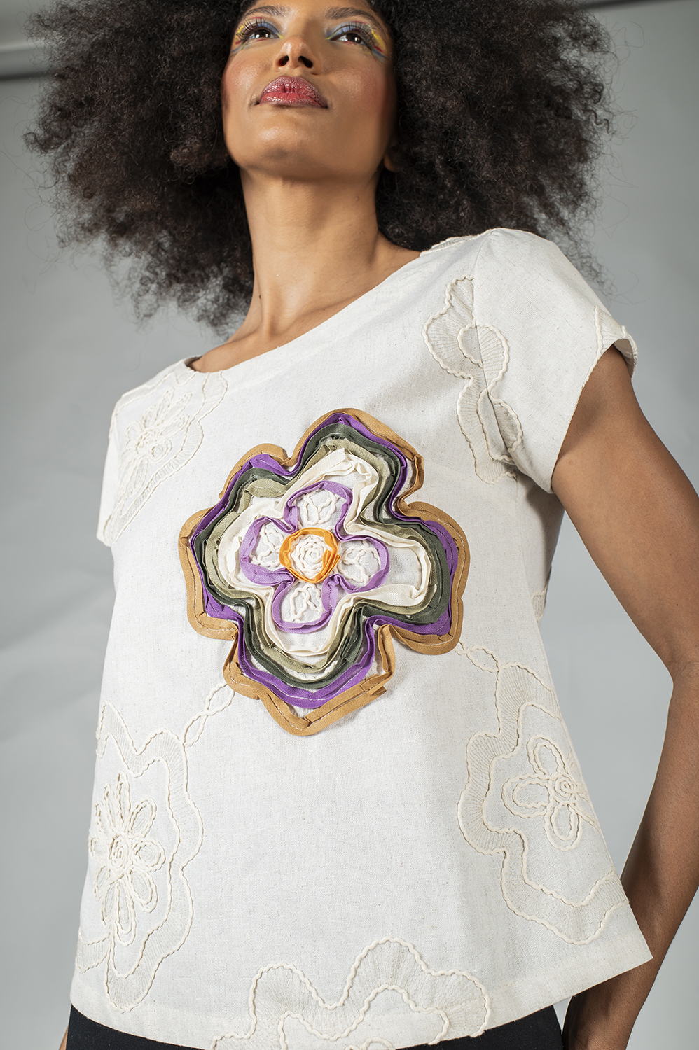 BLUSA RETA COM MANGA CURTA, DECOTE REDONDO, PENCES NO BUSTO CUSTOMIZADA COM APLICAÇÕES MANUAIS DE BORDADO NAS FLORES