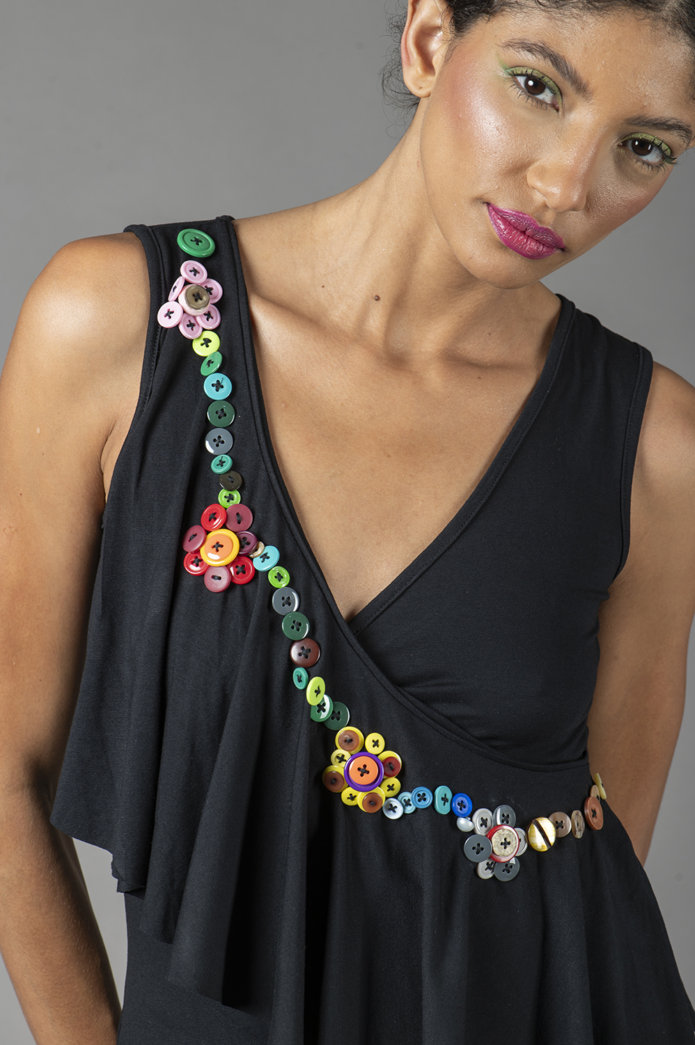 REGATA COM APLICAÇÃO ARTESANAL DE FLORES DE BOTÃO COM JABOT DIAGONAL NA FRENTE