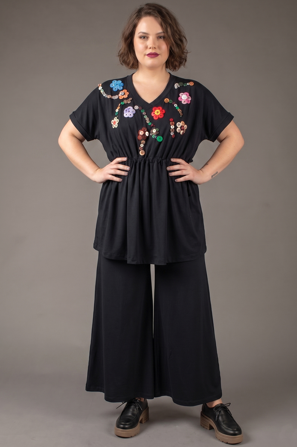 BLUSA PLUS SIZE, COM APLICAÇÃO ARTESANAL DE FLORES DE BOTÃO, BEM SOLTINHA, COM REGULAGEM NA CINTURA, DECOTE V E MANGA CURTA - Imagem 2