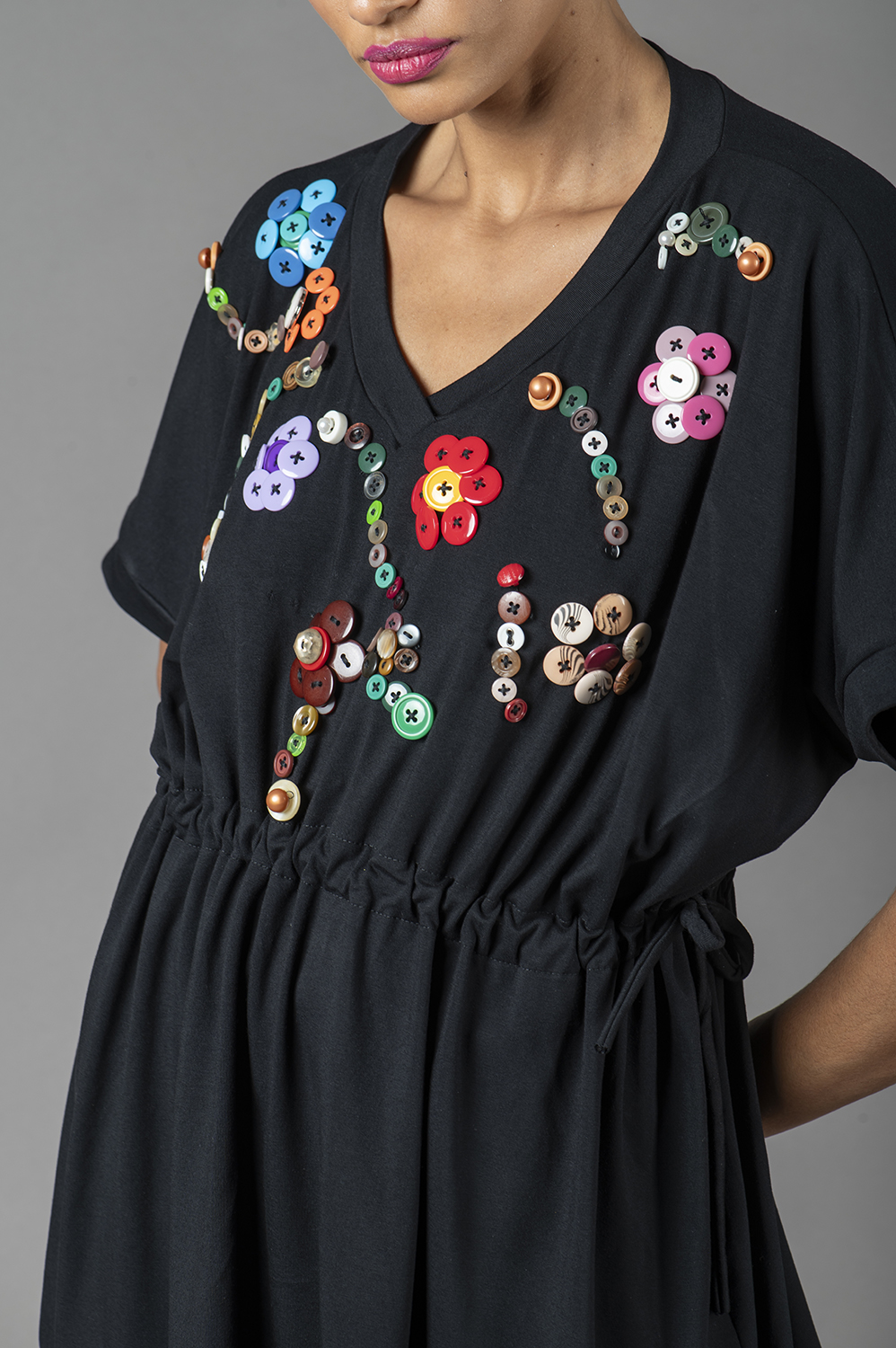 BLUSA PLUS SIZE, COM APLICAÇÃO ARTESANAL DE FLORES DE BOTÃO, BEM SOLTINHA, COM REGULAGEM NA CINTURA, DECOTE V E MANGA CURTA - Imagem 3