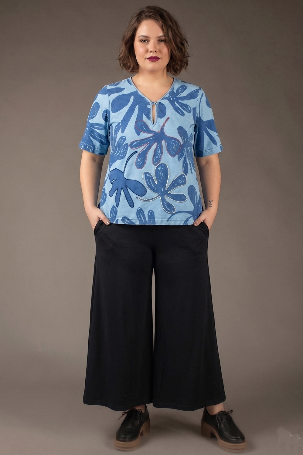 BLUSA PLUS SIZE SOLTINHA, COM DECOTE V TIPO INDIANO, MANGAS MÉDIAS LEVEMENTE SINO E APLICAÇÃO ARTESANAL DE REBORDADO EM ALGUMAS FLORES