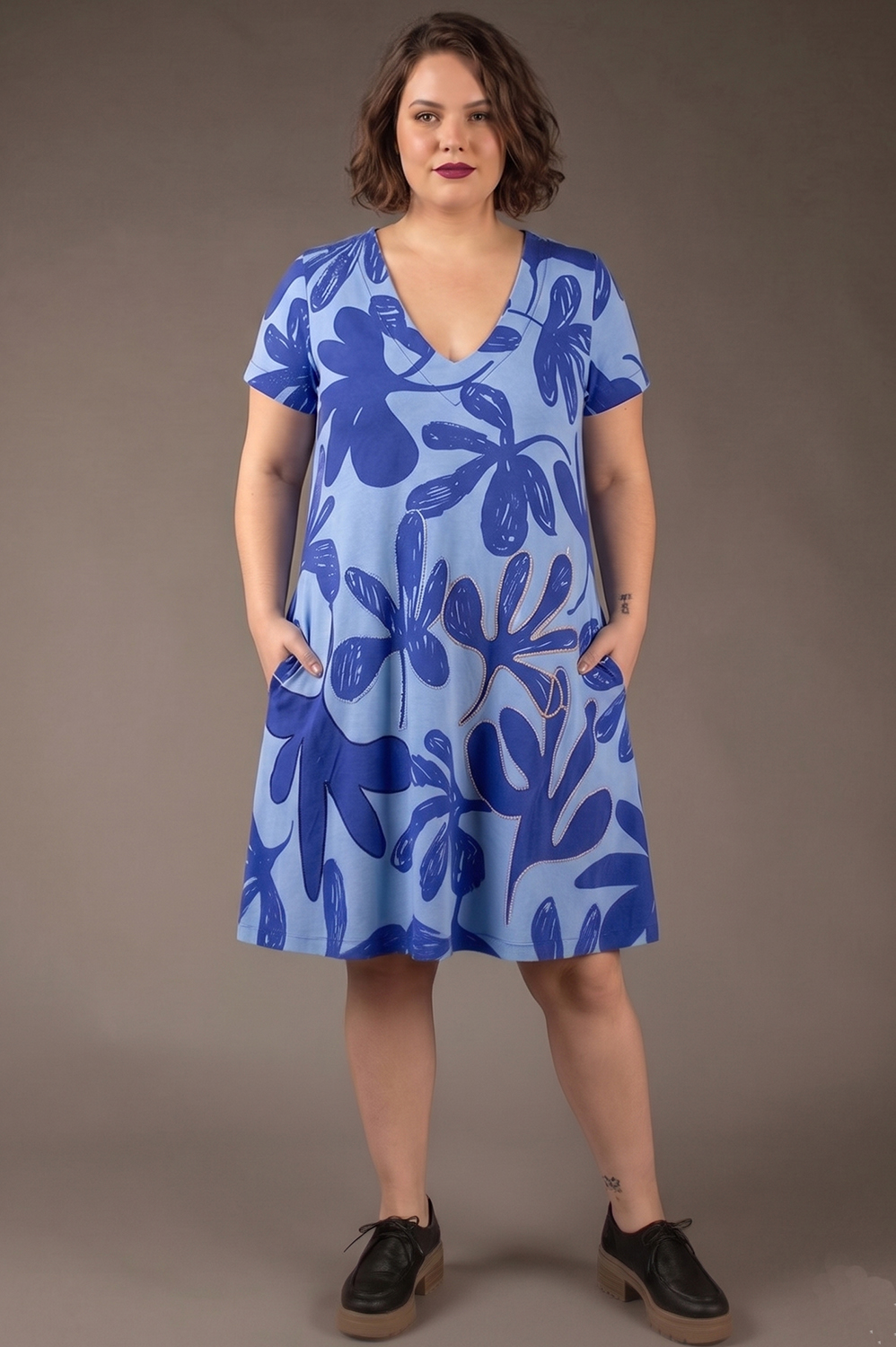 VESTIDO PLUS SIZE LINHA A, COM DECOTE V, BOLSOS, MANGA CURTA E APLICAÇÃO ARTESANAL DE REBORDADO EM ALGUMAS FLORES