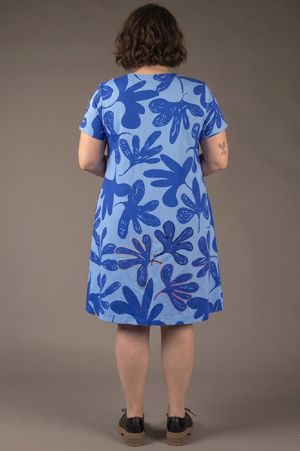 VESTIDO PLUS SIZE LINHA A, COM DECOTE V, BOLSOS, MANGA CURTA E APLICAÇÃO ARTESANAL DE REBORDADO EM ALGUMAS FLORES