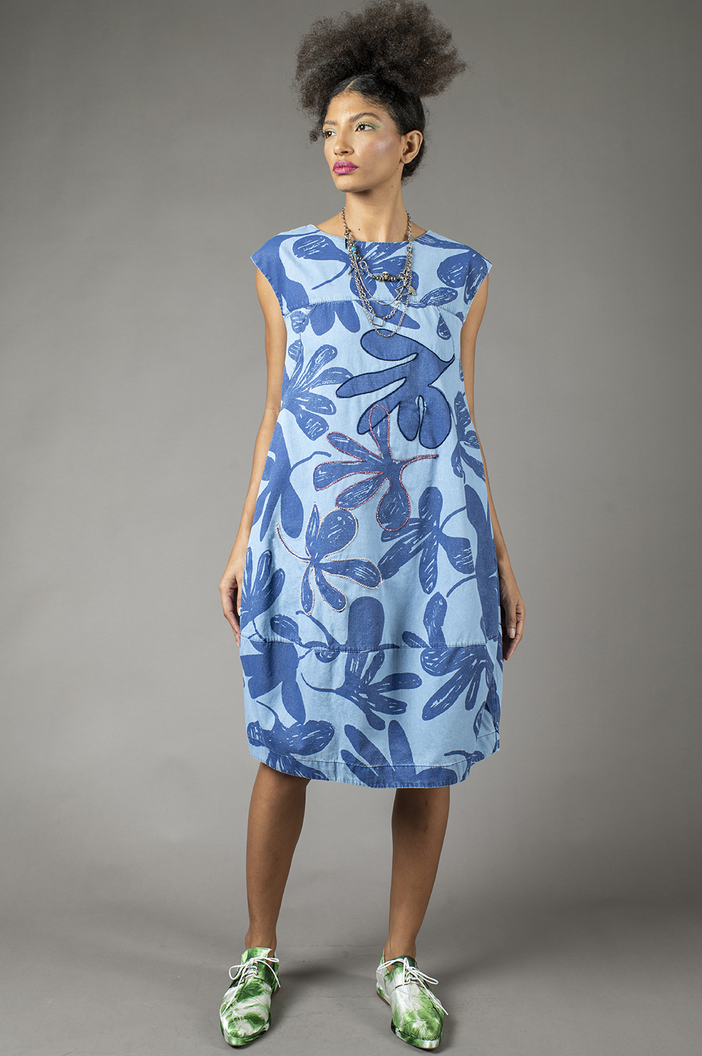 VESTIDO ARREDONDADO COM PALA, BARRADO GEOMÉTRICO E APLICAÇÃO ARTESANAL DE REBORDADO EM ALGUMAS FLORES